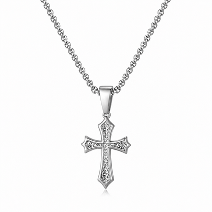 A silver cross pendant necklace with a detailed, textured cross design and clear stones, suspended from a classic curb chain against a plain white background.