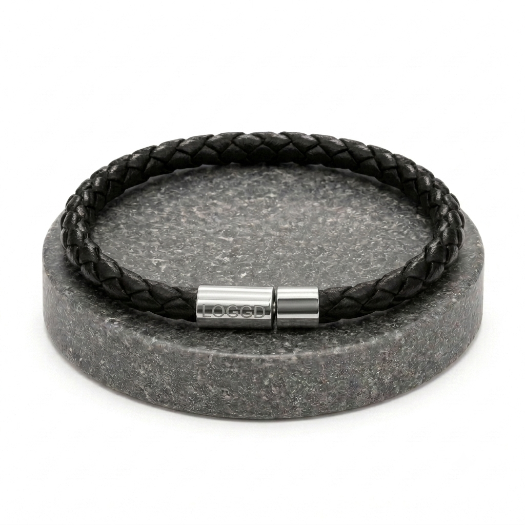 Close-up of a premium minimalist braided leather bracelet for men, featuring a sleek, reflective stainless steel silver clasp.