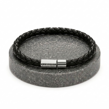 Close-up of a premium minimalist braided leather bracelet for men, featuring a sleek, reflective stainless steel silver clasp.