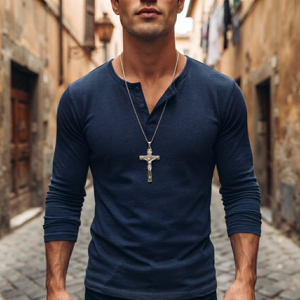 A detailed shot of a man wearing the sterling silver crucifix pendant necklace, resting on his bare chest with a casual open shirt.