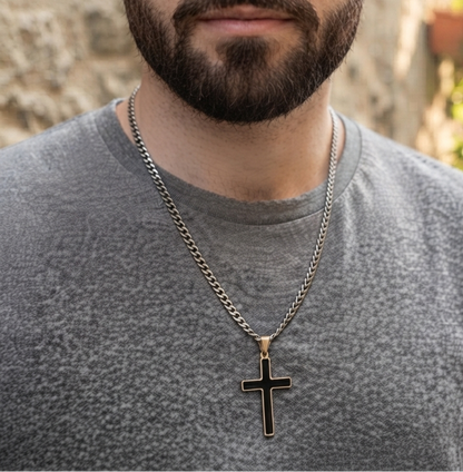 A close-up shot of a stylish man wearing the silver cross pendant necklace layered with the matching curb chain