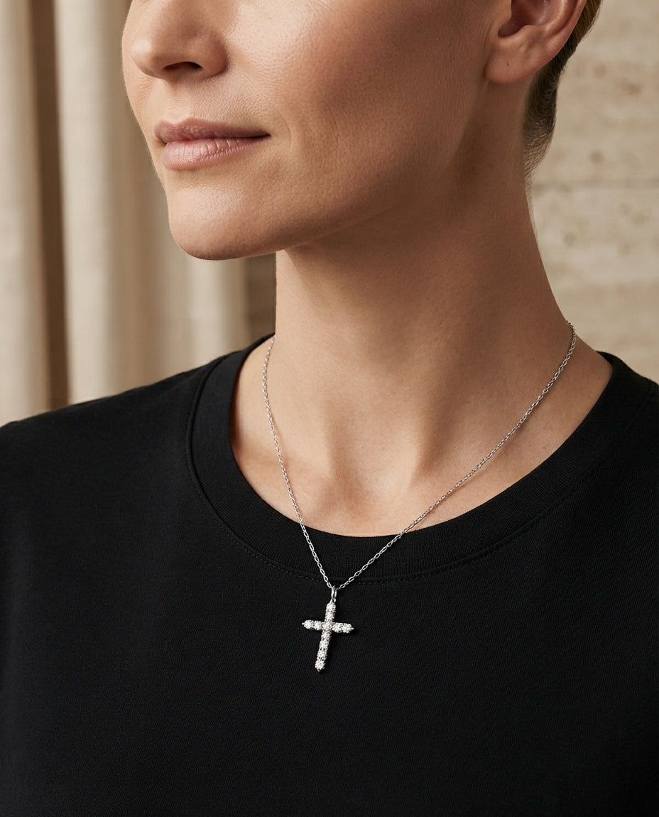 Close-up of a person wearing the sparkling pavé cross necklace, showing the pendant resting gracefully against their collarbone.